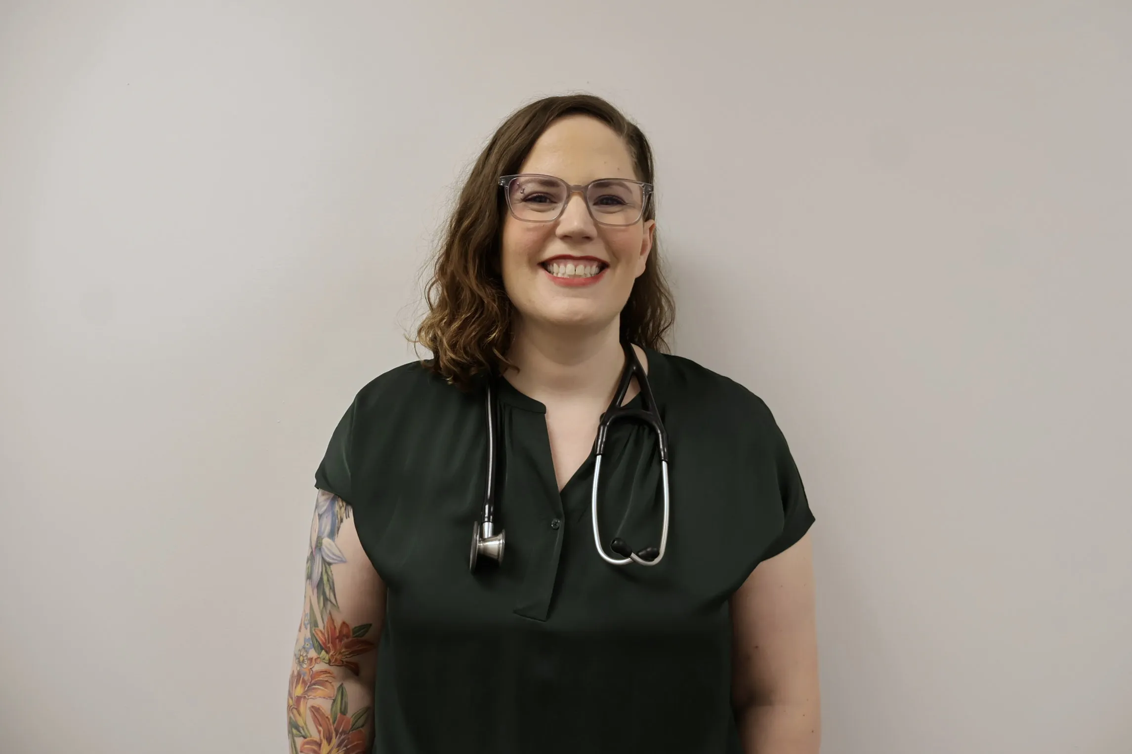 Dr. Amanda Oropeza smiling, wearing a dark green top and a stethoscope.